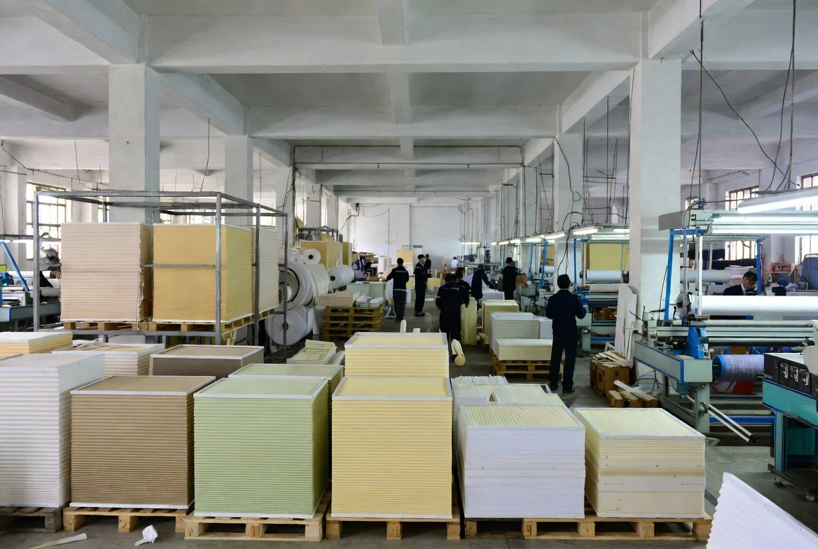 Stacks of pleated honeycomb fabric in several colours waiting for assembly